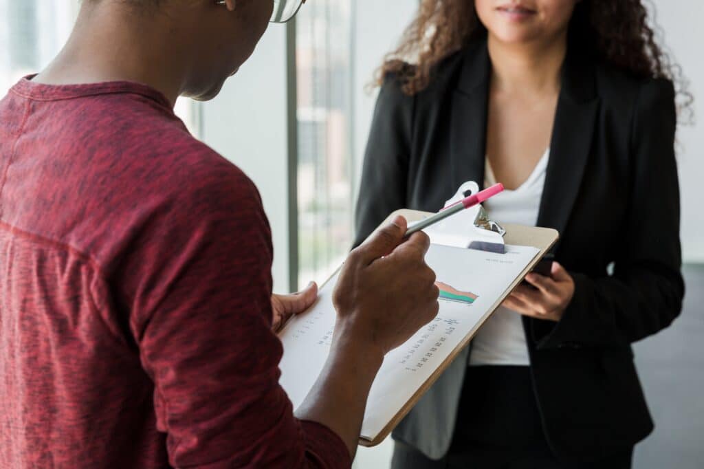 Man with clipboard talking to woman
