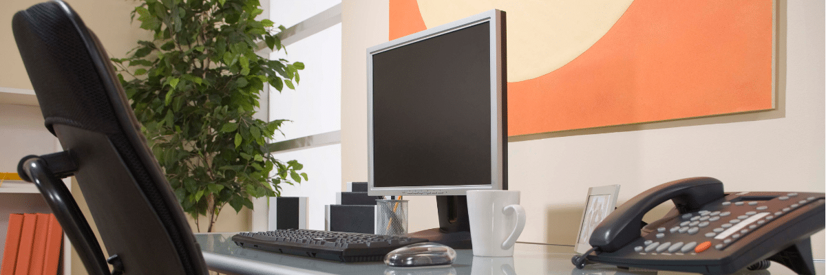 a computer monitor and a mug on a desk