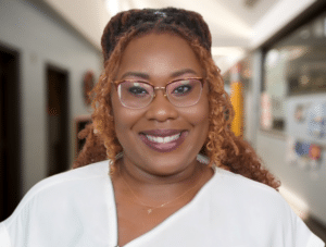 a woman wearing glasses and a white shirt