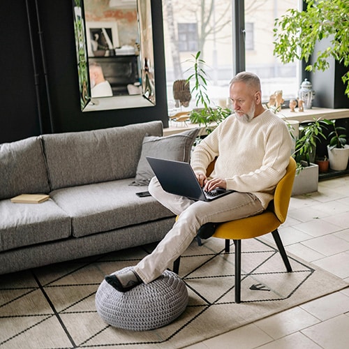a man sitting in a chair using a laptop