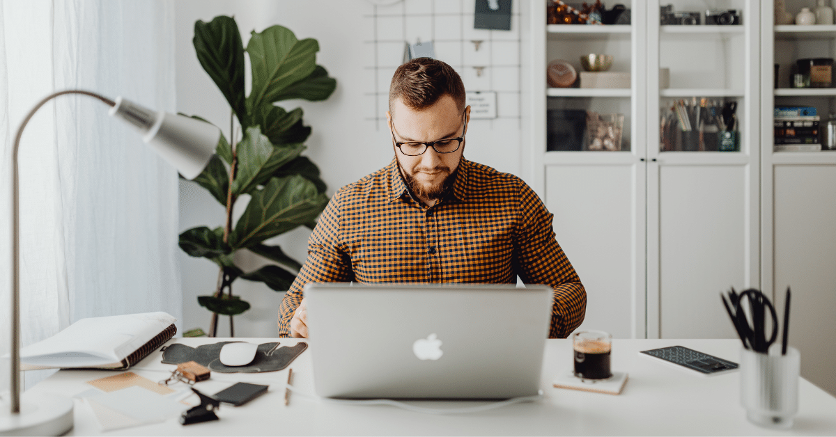 a man sitting at a desk with a laptop