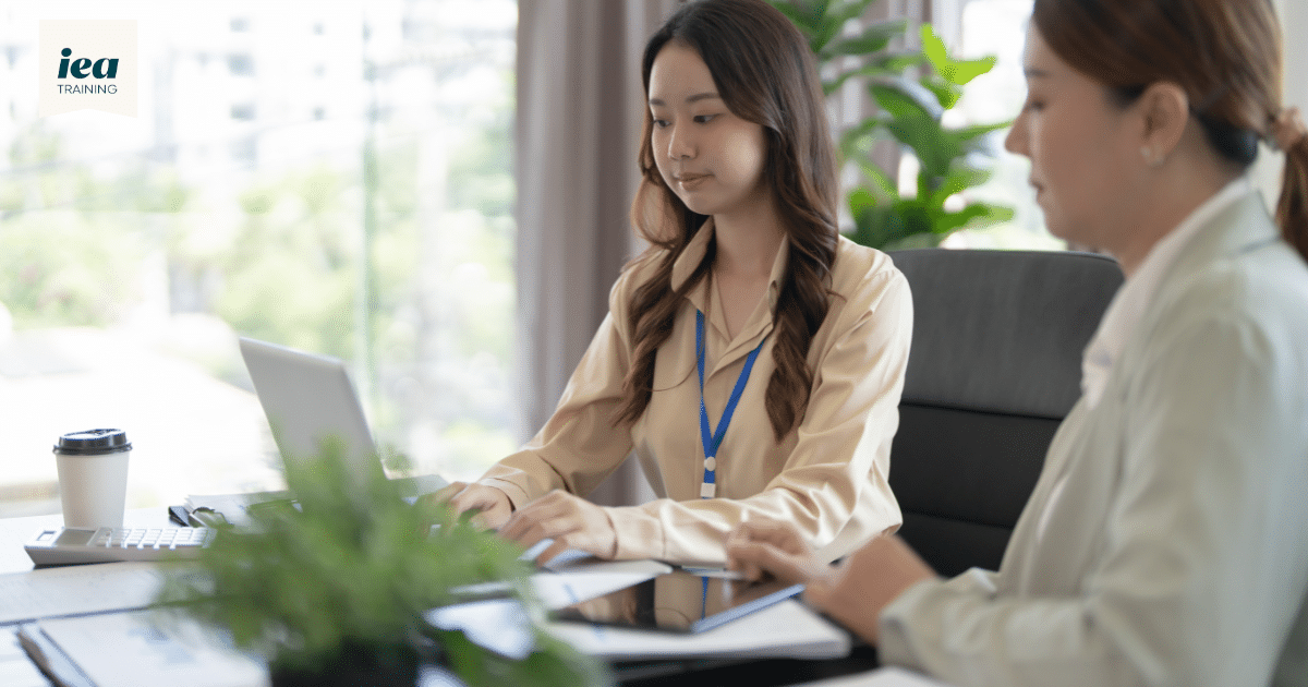 Adjuster on-the-job training: a trainee working on a laptop beside her supervisor